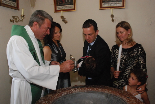 Ein Kind wird getauft in der Pfarrkirche Deutschfeistritz